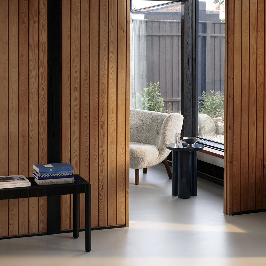 Neutral tones with rich wooden textures and sleek black accents create a modern, cozy aesthetic for interior decor.