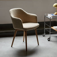 Beige textured armchair with light wooden legs, perfect for modern interiors. Elegant and stylish design.