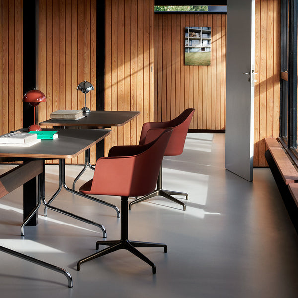 "Modern workspace featuring rich brown chairs, sleek metal accents, and warm wood paneling in a minimalist design."