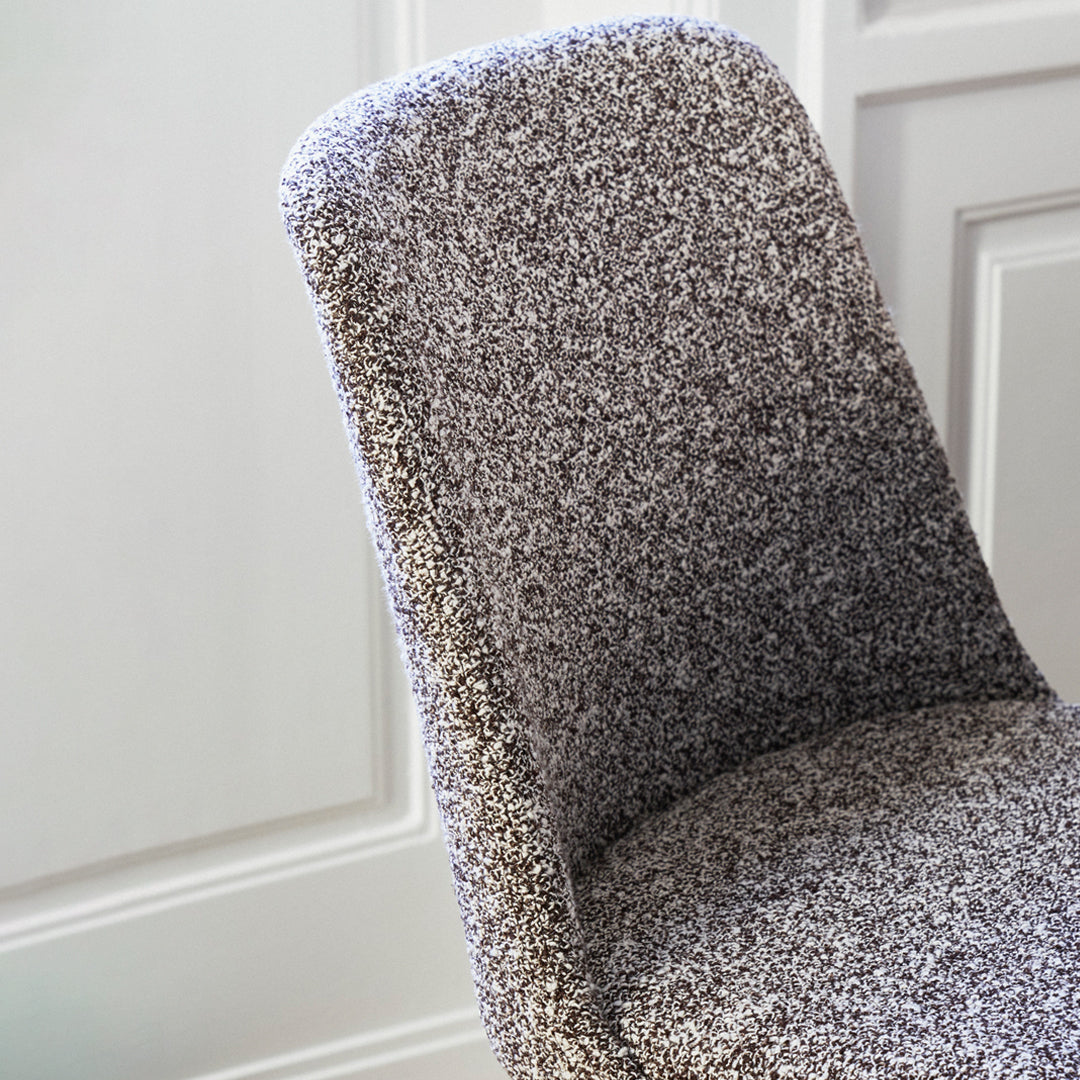 Gray textured chair with a soft, speckled pattern, complementing modern interiors.