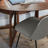 Gray fabric chair beside a wooden desk with a smooth finish and warm tones, set on light wooden flooring.