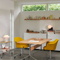Bright yellow chairs and a light wood table in a modern workspace with neutral walls and a minimalist decor.