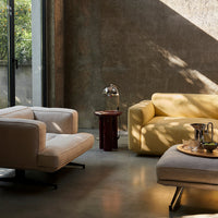 Stylish beige and vibrant yellow sofas with modern patterns in a beautifully lit, textured interior space.
