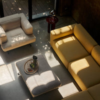 "Modern living room with yellow and gray furniture, featuring soft textures and natural light patterns."