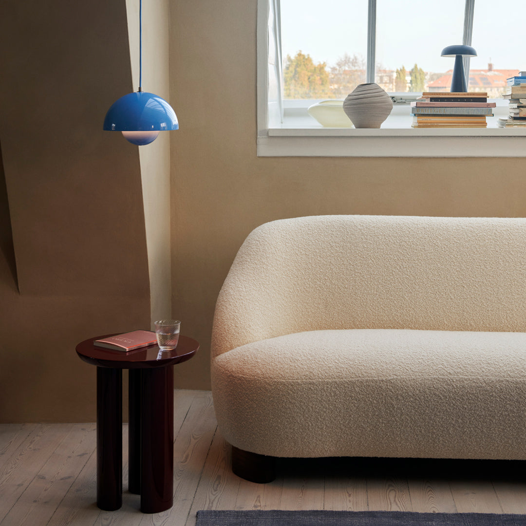 Beige textured sofa with a blue lamp and dark wood side table, creating a warm, modern living space.