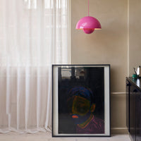 Framed artwork featuring vibrant colors with neon highlights, complemented by a bold pink pendant lamp.