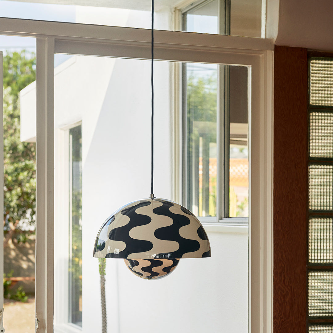 Black and white wavy patterned pendant lamp hanging in a bright, airy space, showcasing modern design.