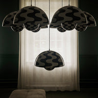 Black and white wavy patterned pendant lights hanging against a soft-lit window backdrop.