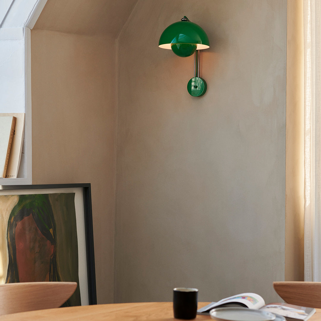 Green modern wall lamp against a neutral wall, complementing a minimalist interior design.