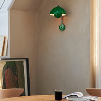 Green modern wall lamp against a neutral wall, complementing a minimalist interior design.