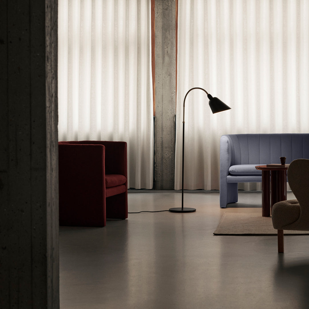 Stylish modern seating in deep red and soft blue, with neutral tones and clean lines, illuminated by soft lighting.