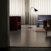 "Modern living room with red and blue sofas, neutral walls, and soft light filtering through sheer curtains."