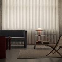 "Elegant beige textured curtains with subtle vertical stripes; modern gray sofa, wooden side table, and neutral accents."
