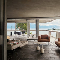 Modern living room featuring neutral tones, earthy browns, and sleek geometric patterns in a stylish outdoor setting.