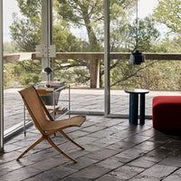 Natural wood tones, bold red upholstery, and sleek black accents create a modern, vibrant living space.