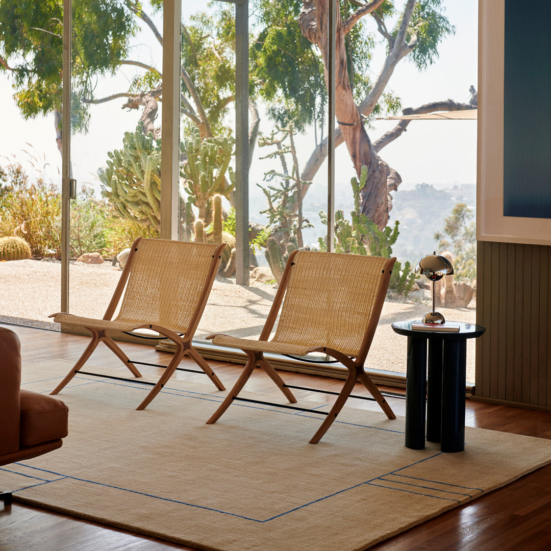 Natural woven texture in warm beige tones paired with a modern black and blue accent table on a light rug.
