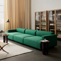 Stylish green sofa with a modern, minimalist design, complemented by light wood accents and subtle textures.