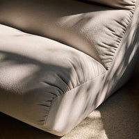 Beige textured sofa close-up showcasing soft folds and subtle shadows. Perfect for modern interiors.