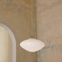 Sleek white pendant lamp hanging against a textured, muted beige and blue wall. Elegant and modern design.