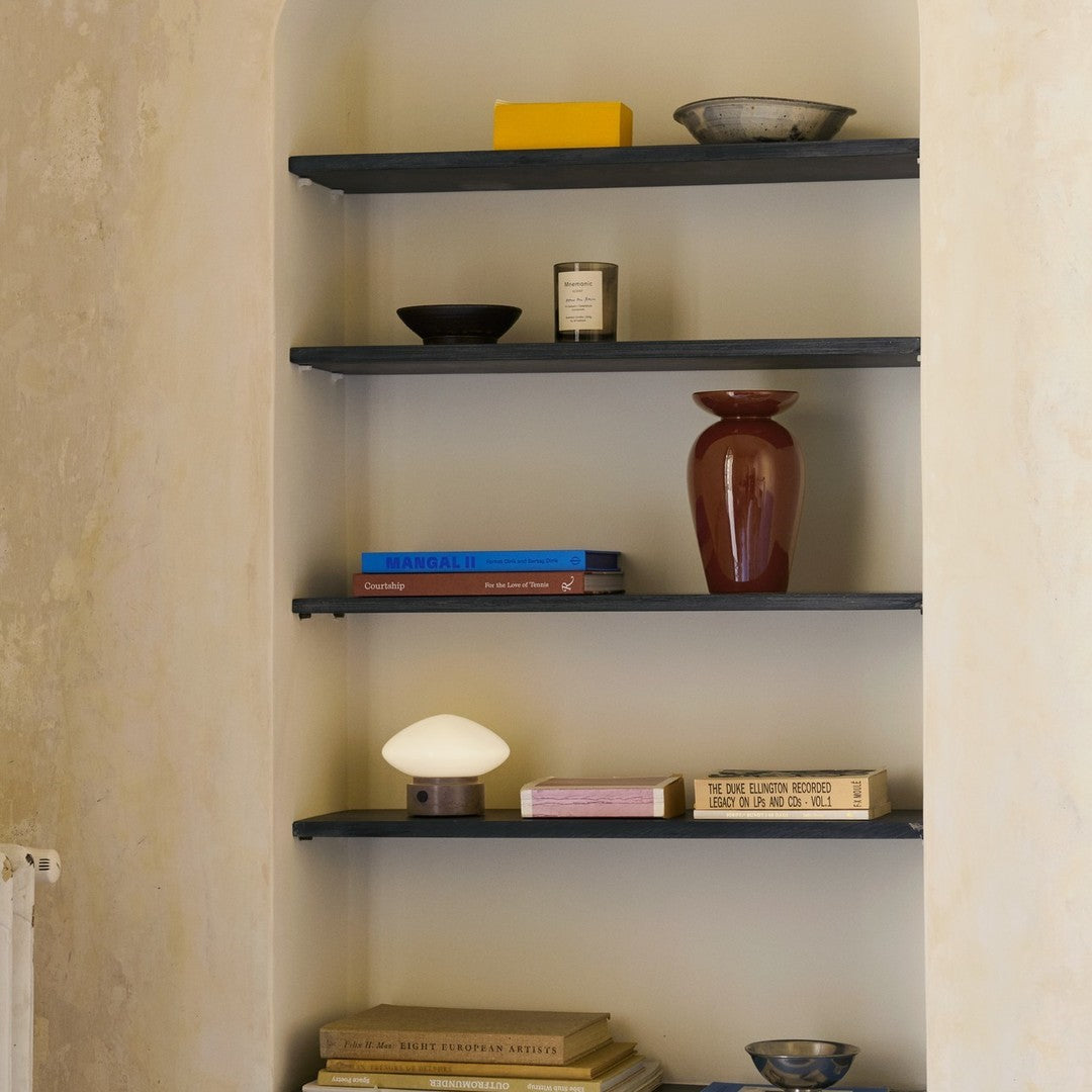 Stylish dark shelves with earthy tones, vibrant yellow, and deep red accents, featuring various textured decorations.