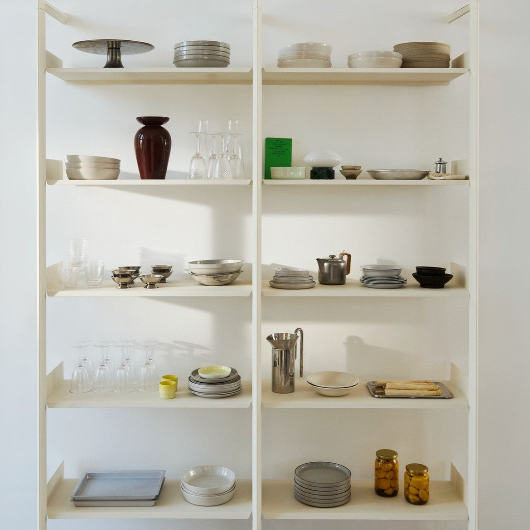 Neutral and vintage kitchenware featuring beige, white, dark brown, and green accents on open shelves.