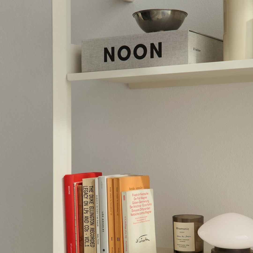 Stylish bookshelf featuring gray, black, orange, and cream tones with modern minimalist patterns.