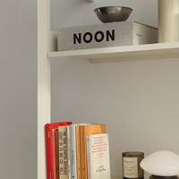 Stylish bookshelf featuring gray, black, orange, and cream tones with modern minimalist patterns.