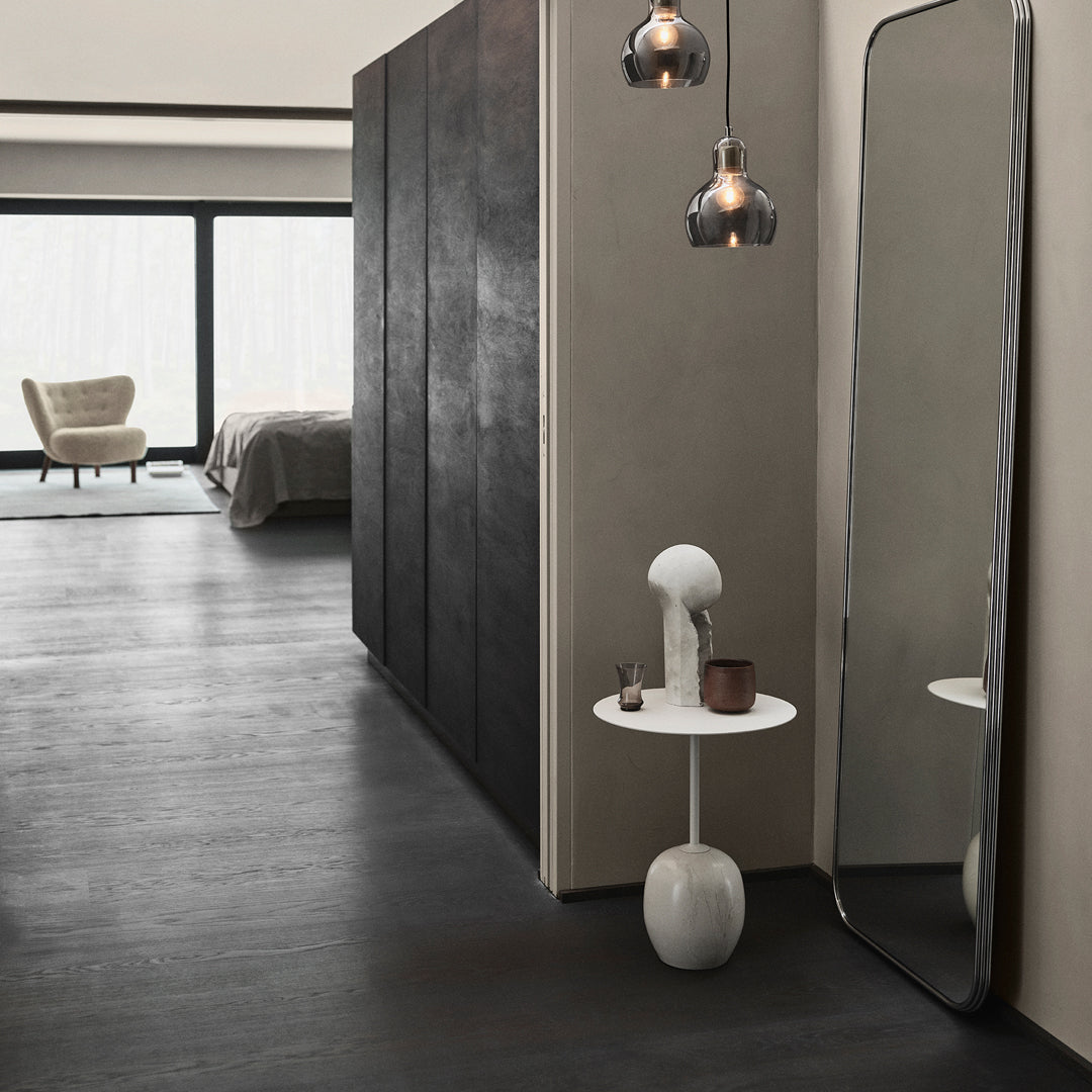 Modern interior featuring dark gray walls, white accents, and warm metallic tones from pendant lights. Sleek and minimalist design.