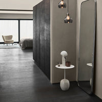 Modern interior featuring dark gray walls, white accents, and warm metallic tones from pendant lights. Sleek and minimalist design.