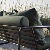 "Dark green outdoor sofa with plush cushions and a sleek black metal frame, perfect for modern patios."