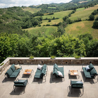 "Luxurious outdoor lounge chairs in deep green fabric and neutral cushions, set against a scenic nature backdrop."