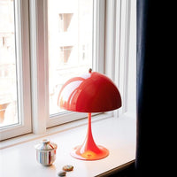 Coral Panthella table lamp on a windowsill with a blurred background