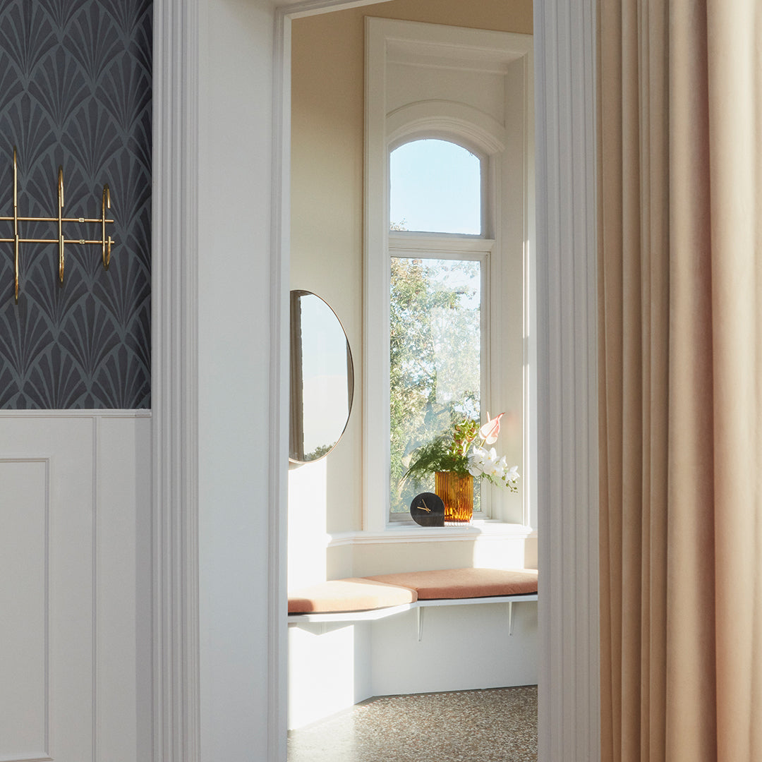 "Elegant geometric wallpaper in dark gray, paired with soft cream curtains and a natural wood accent."