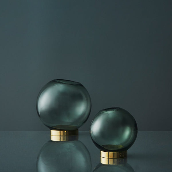 "Set of two rounded glass vases in smoky gray with sleek gold bases, showcasing minimalistic elegance for modern decor."