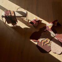 "Cozy home décor featuring earthy reds, soft pinks, and abstract floral patterns on a rug and cushions."