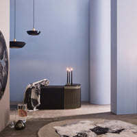 "Modern room with soft blue walls, black accents, and a patterned beige rug featuring abstract black and white designs."