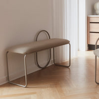 Beige upholstered bench with a minimalist silver frame, featuring smooth curves and a contemporary design.