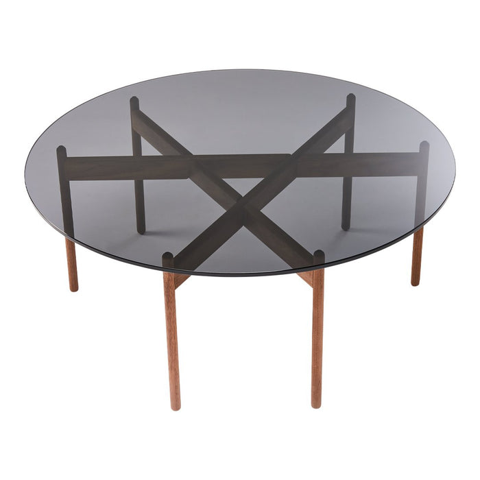 Round glass table with a smoky gray top and walnut wood base featuring an intersecting cross pattern.