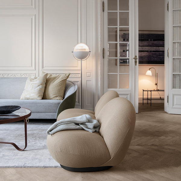 Beige curved sofa with a textured surface, paired with a soft gray backdrop and subtle wood accents.