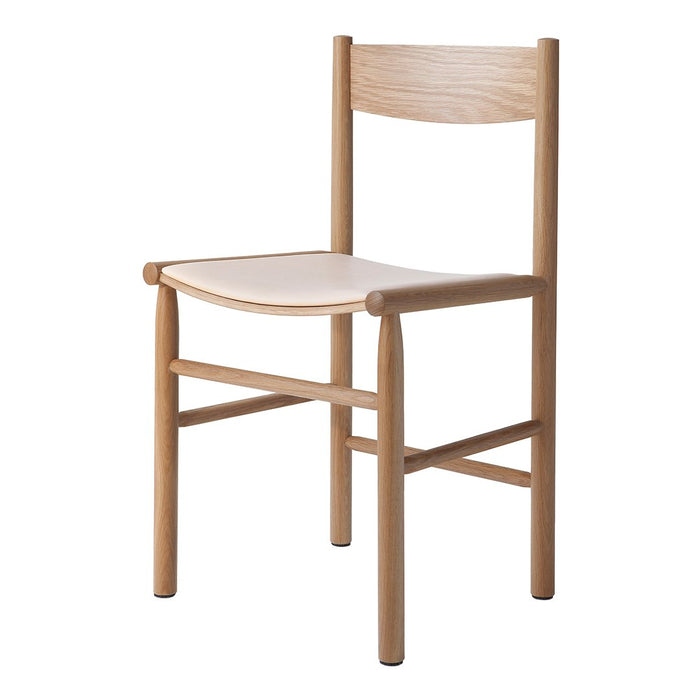 Light wood chair with a natural finish and a smooth white seat, featuring minimalist design and clean lines.
