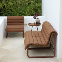 Brown padded lounge chairs with a sleek design, set against a minimalistic white backdrop.