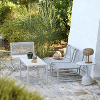 Gray outdoor furniture set with sleek lines and a minimalist design against a natural green backdrop.
