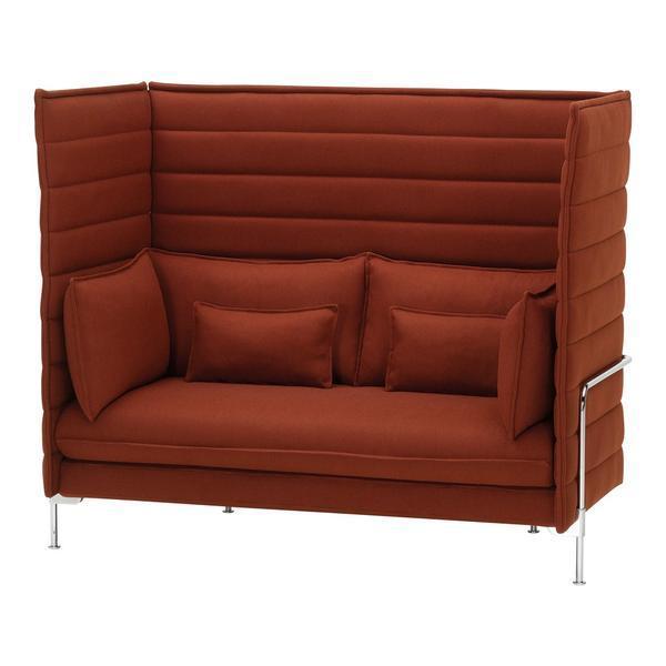 Rust-orange upholstered sofa with padded stripes and silver legs, featuring matching throw pillows.