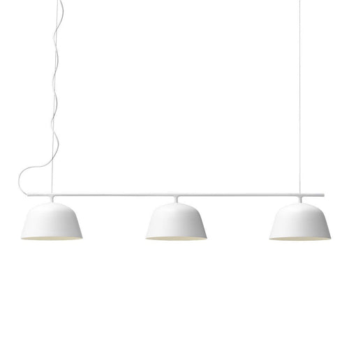 Three sleek white pendant lights with smooth, curved, matte finish shades. Minimalist design with subtle elegance.