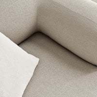 Beige textured upholstery with a light throw pillow, showcasing subtle patterns and a cozy aesthetic.