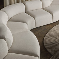 Beige sectional sofa with a modern design on a wooden floor.