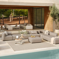 "Modern outdoor sectional sofa in neutral beige tones with a textured fabric, paired with a light gray rug."