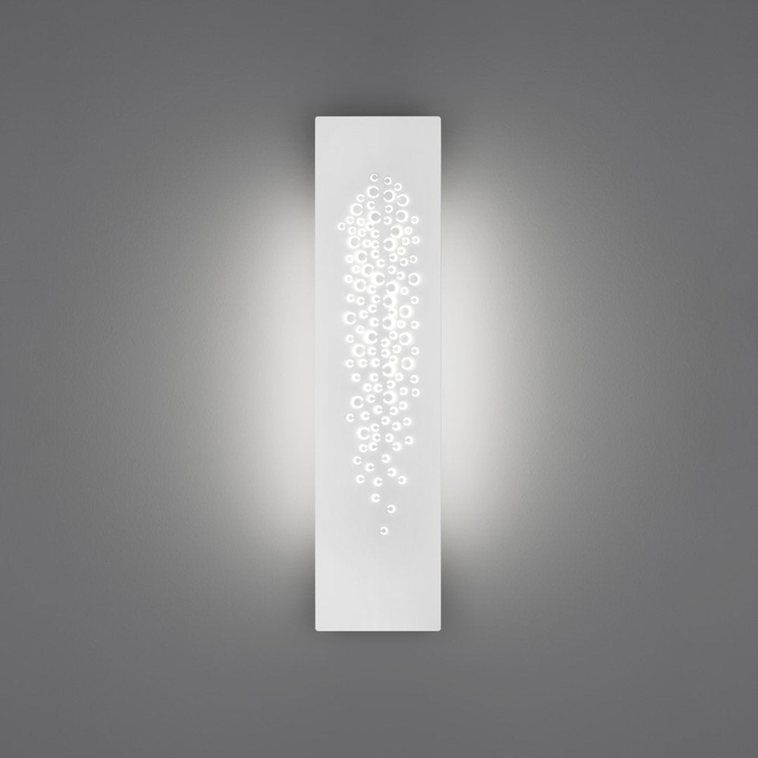 Sleek white wall sconce with a delicate pattern of cascading dots, enhancing ambient lighting against a gray background.