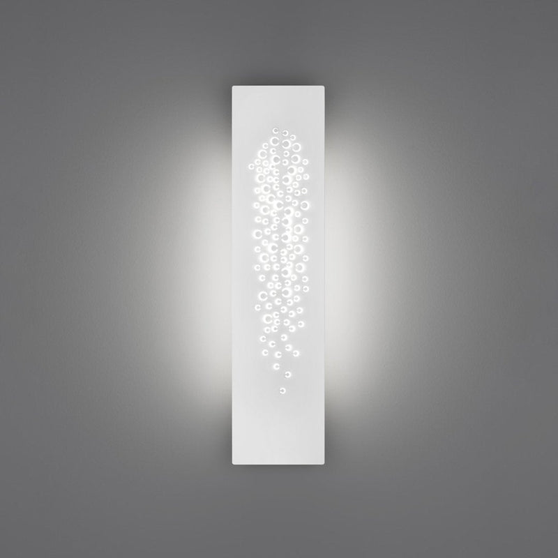 Sleek white wall sconce with a delicate pattern of cascading dots, enhancing ambient lighting against a gray background.