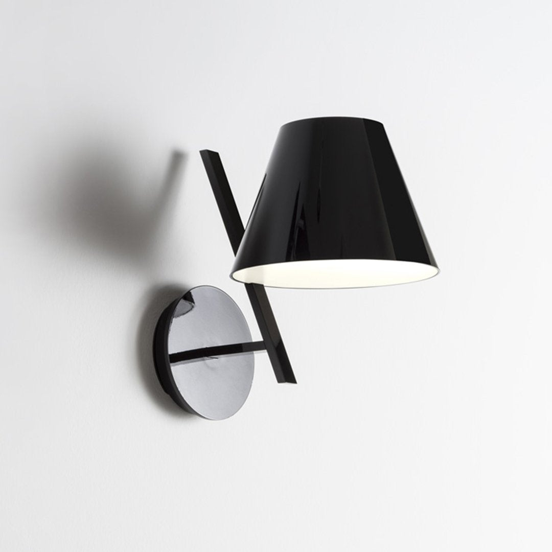 Black and chrome wall lamp with a modern, minimalist design featuring a sleek, glossy finish.